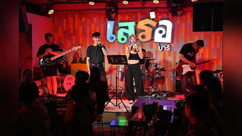 A singer performing into a microphone under stage lights
